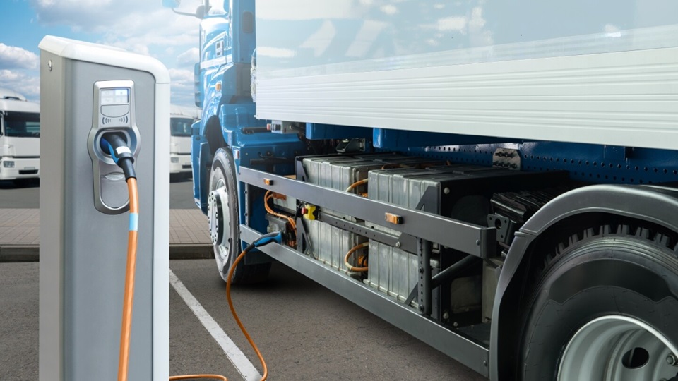 A long haul truck plugged into an electric vehicle charger.