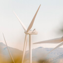 A lone wind turbine with sky and clouds in the background. 