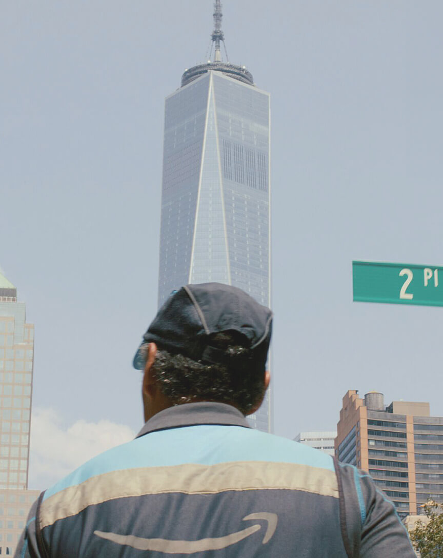 A person is shown in front of a skyscraper building.