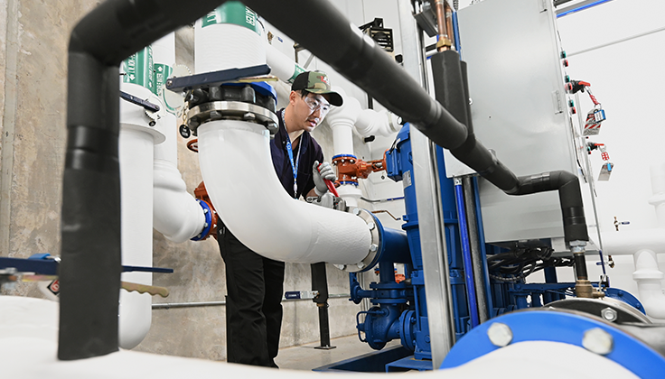 A person inspecting a pipe.