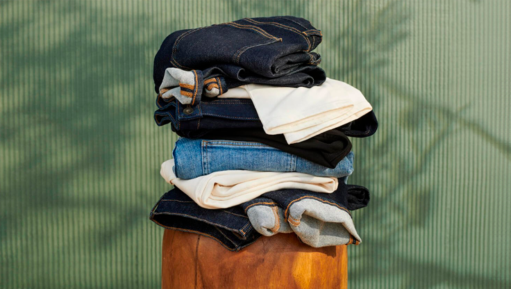 A stack of folded clothes against a green background.