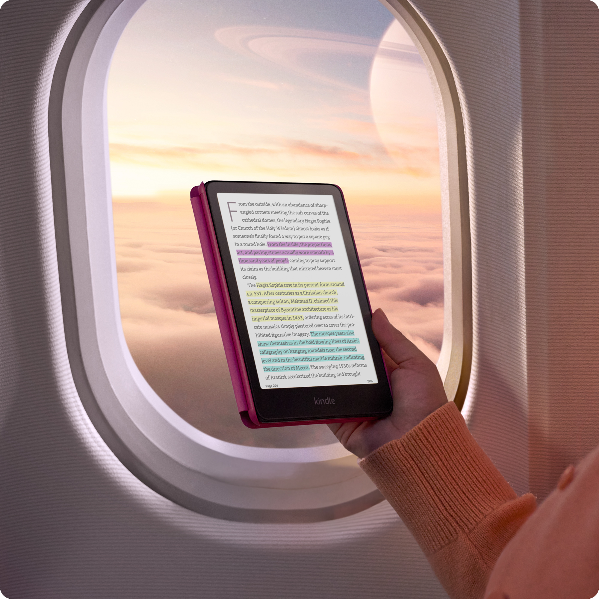A person reading a Kindle next to an airplane window. 
