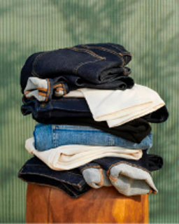 A stack of folded clothes against a green background. 