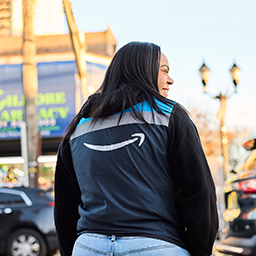 A person wearing an Amazon vest with the Amazon smile logo on it.