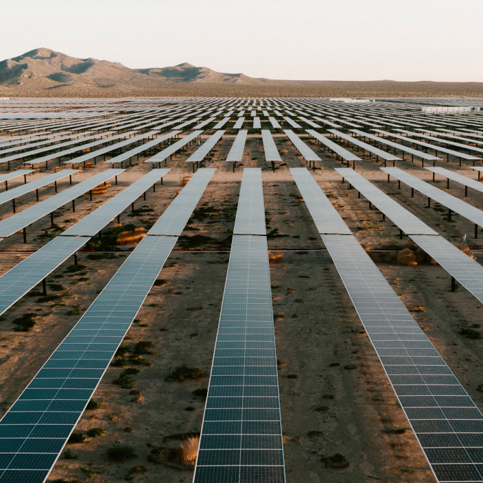 Rows of solar panels in a desert landscape.
