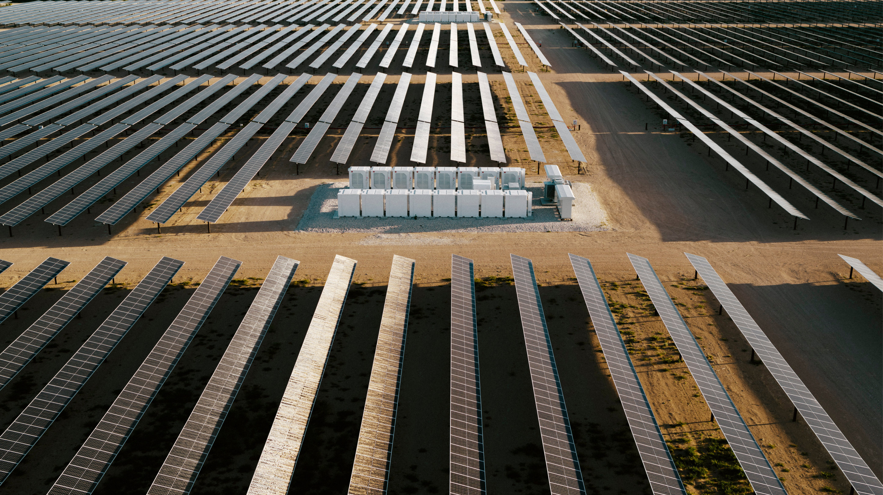 Rows of solar panels in a desert landscape. 