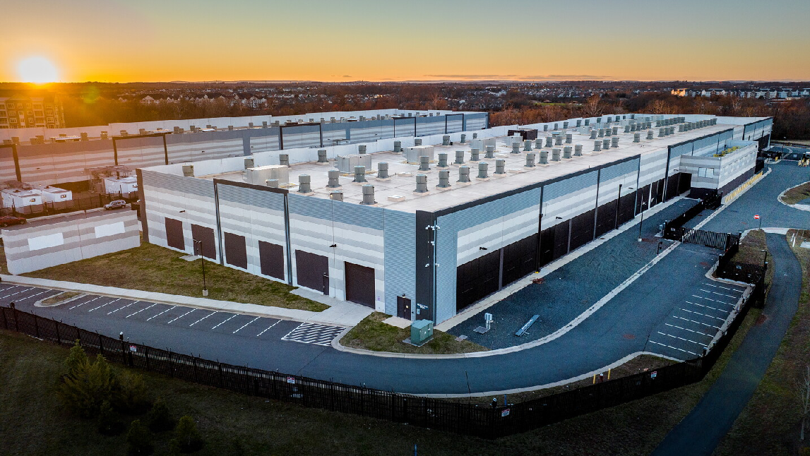 A wide view of the exterior of a building at sunset. 