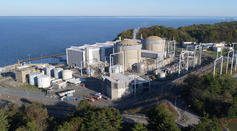Buildings that resemble a factory perched on a cliffside that overlooks the sea. 