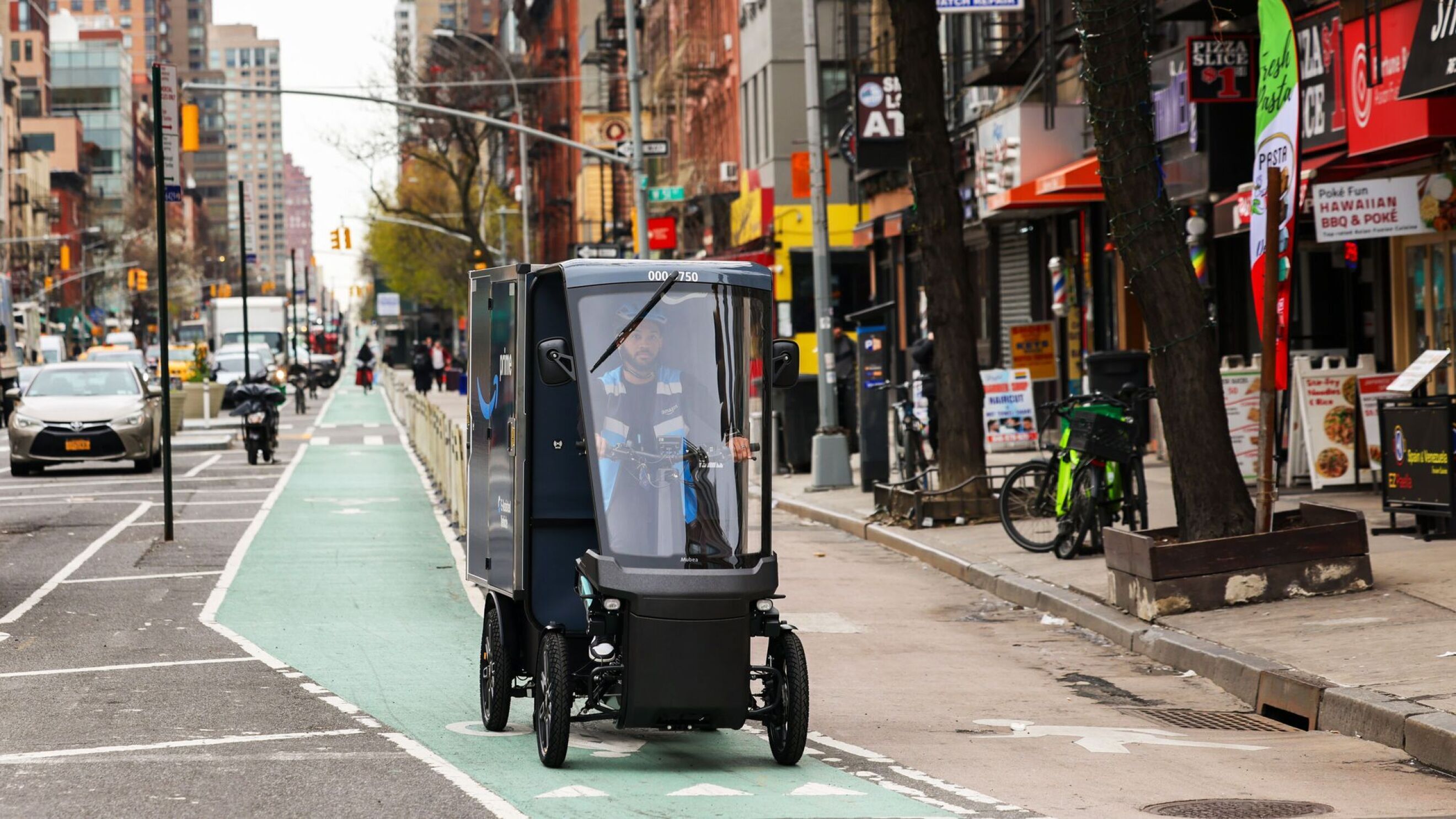 A person drives an e-bike delivery vehicle through a bust city street. 
