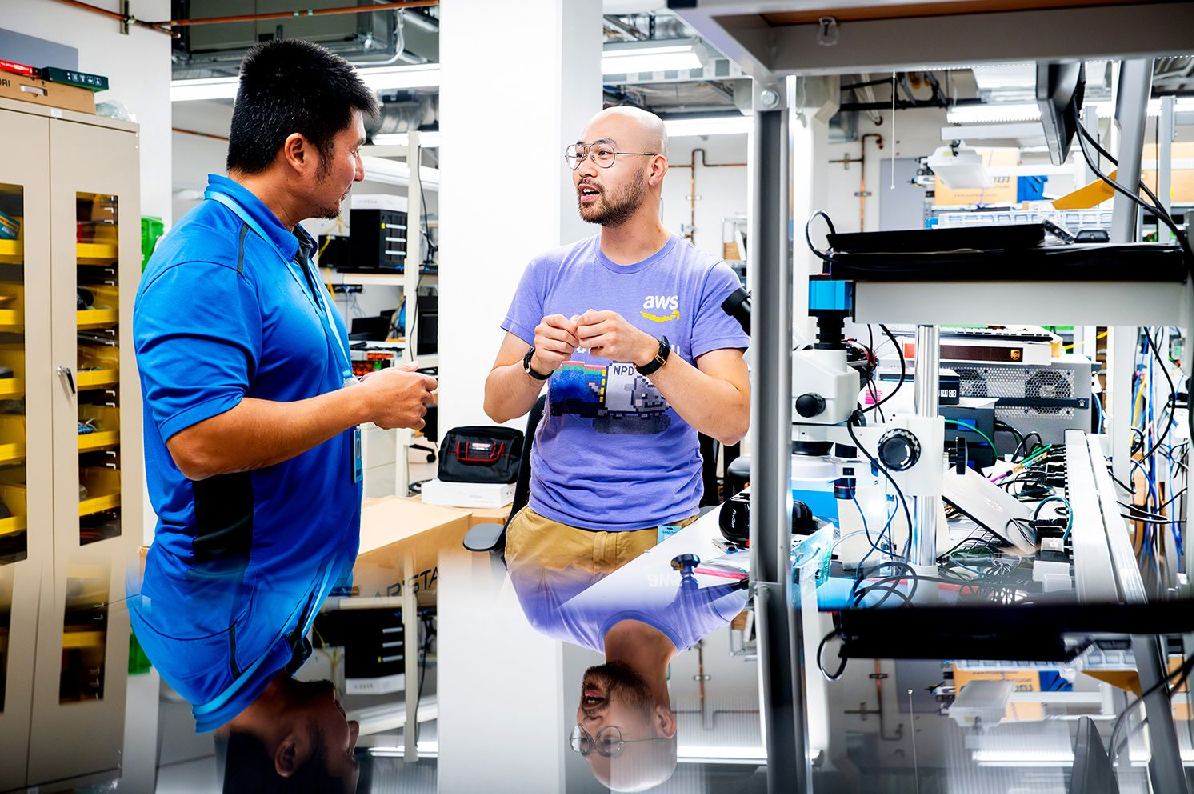 Two people chat while working in a lab setting. 