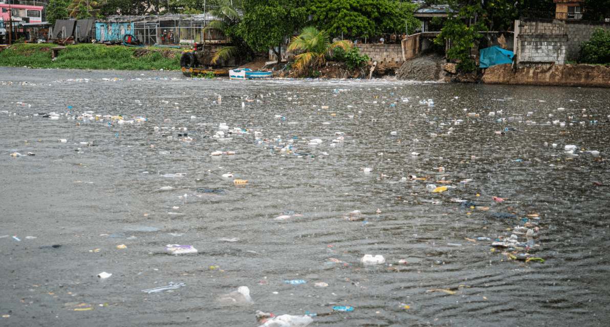Scattered trash floats at the surface of a body of water. 
