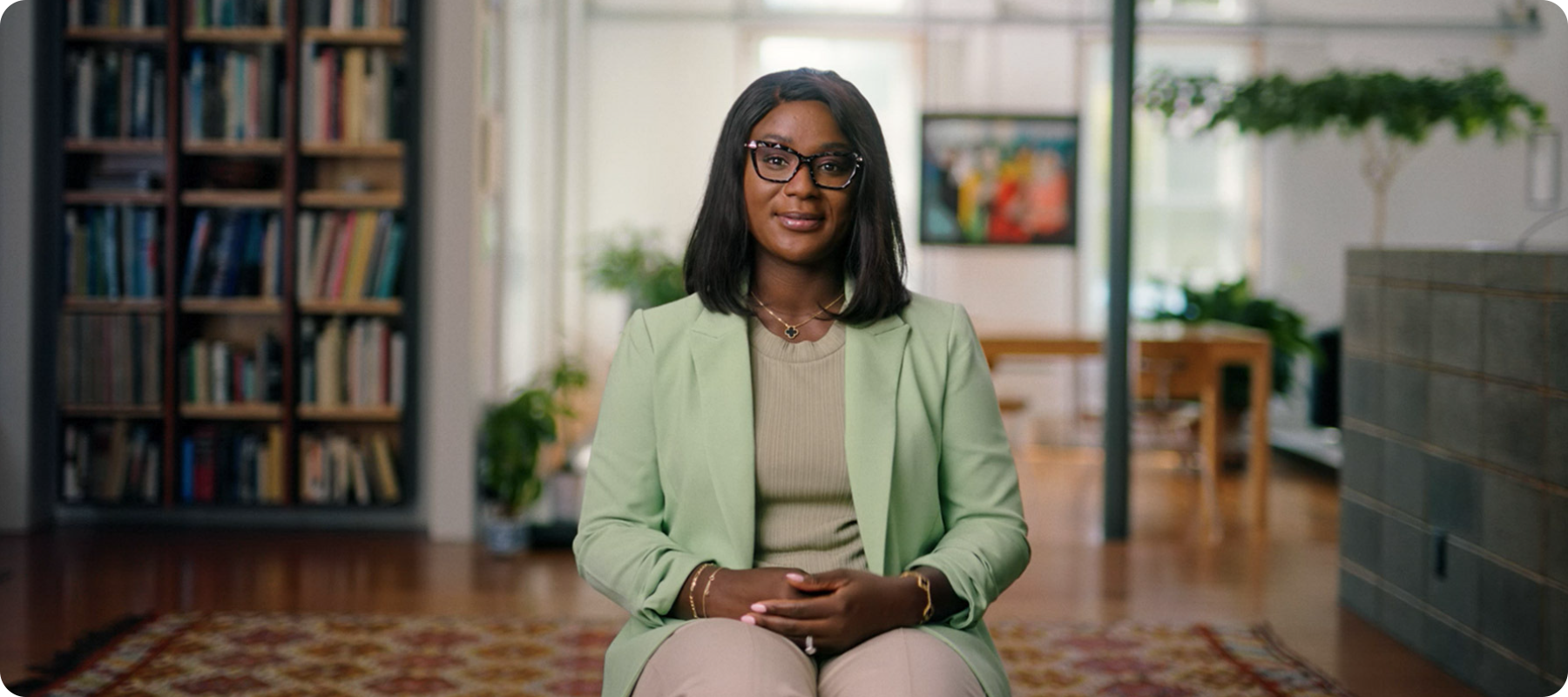 A person sits in a room, smiling at the camera. 