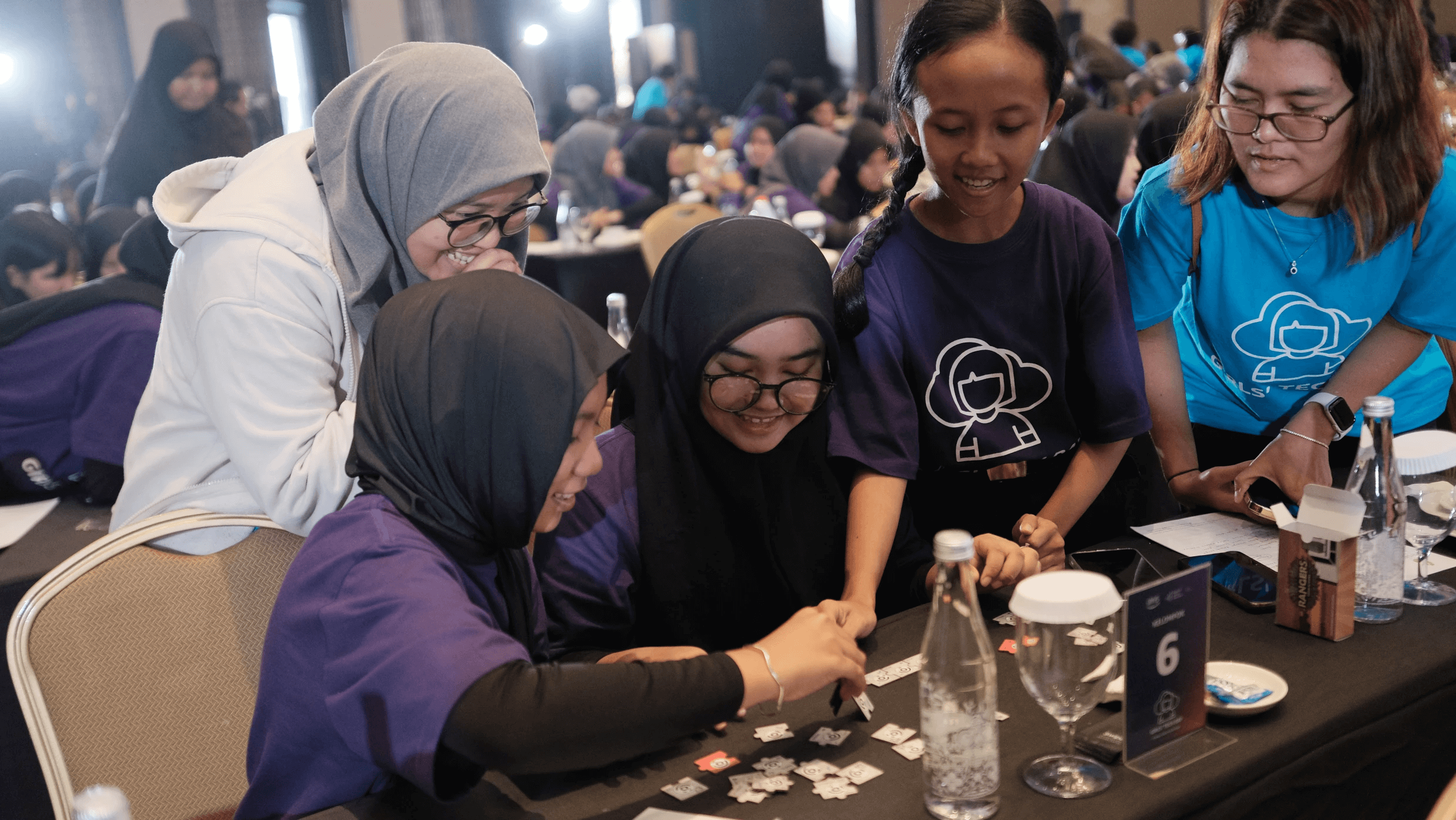 A group of smiling children gather around a table.
