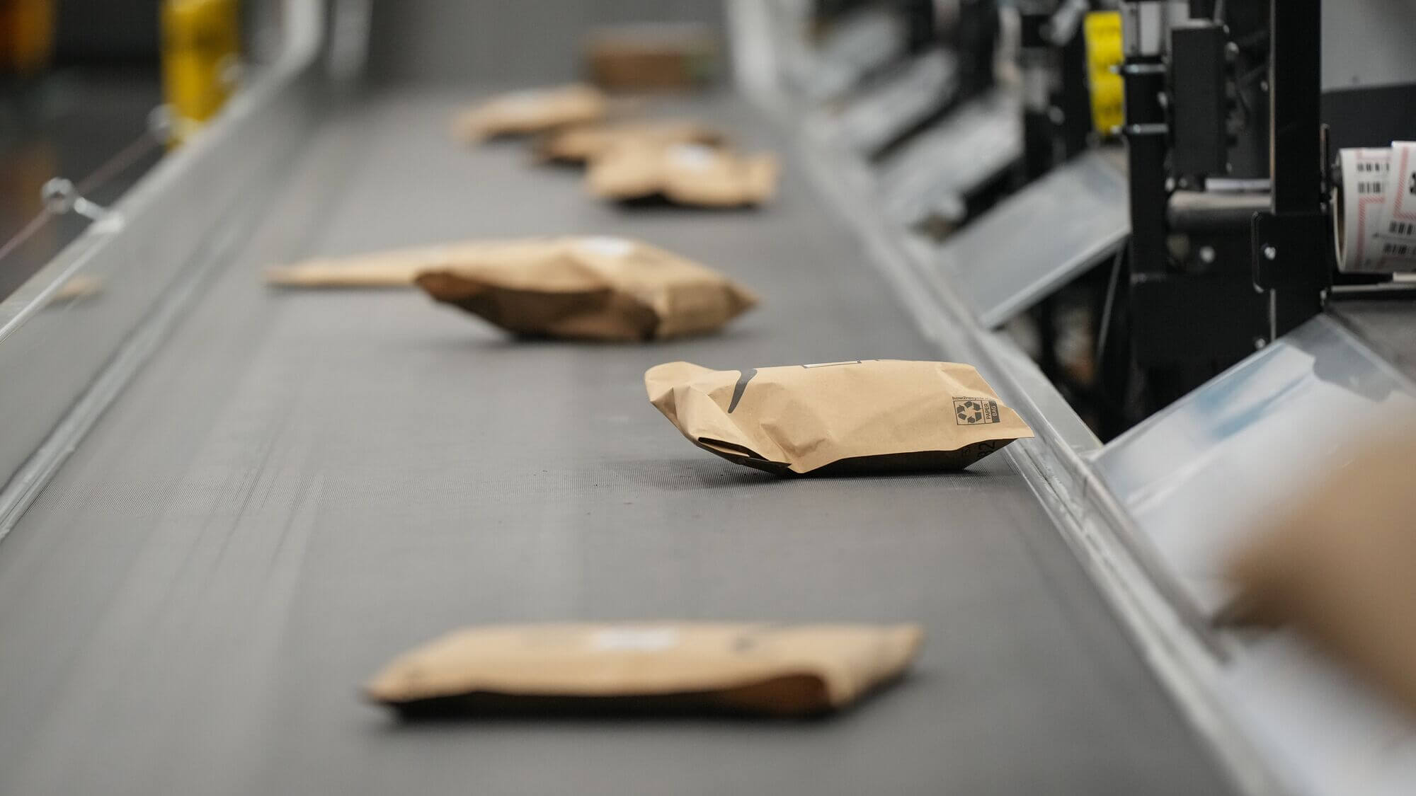 Amazon packages sit on a conveyor belt. 