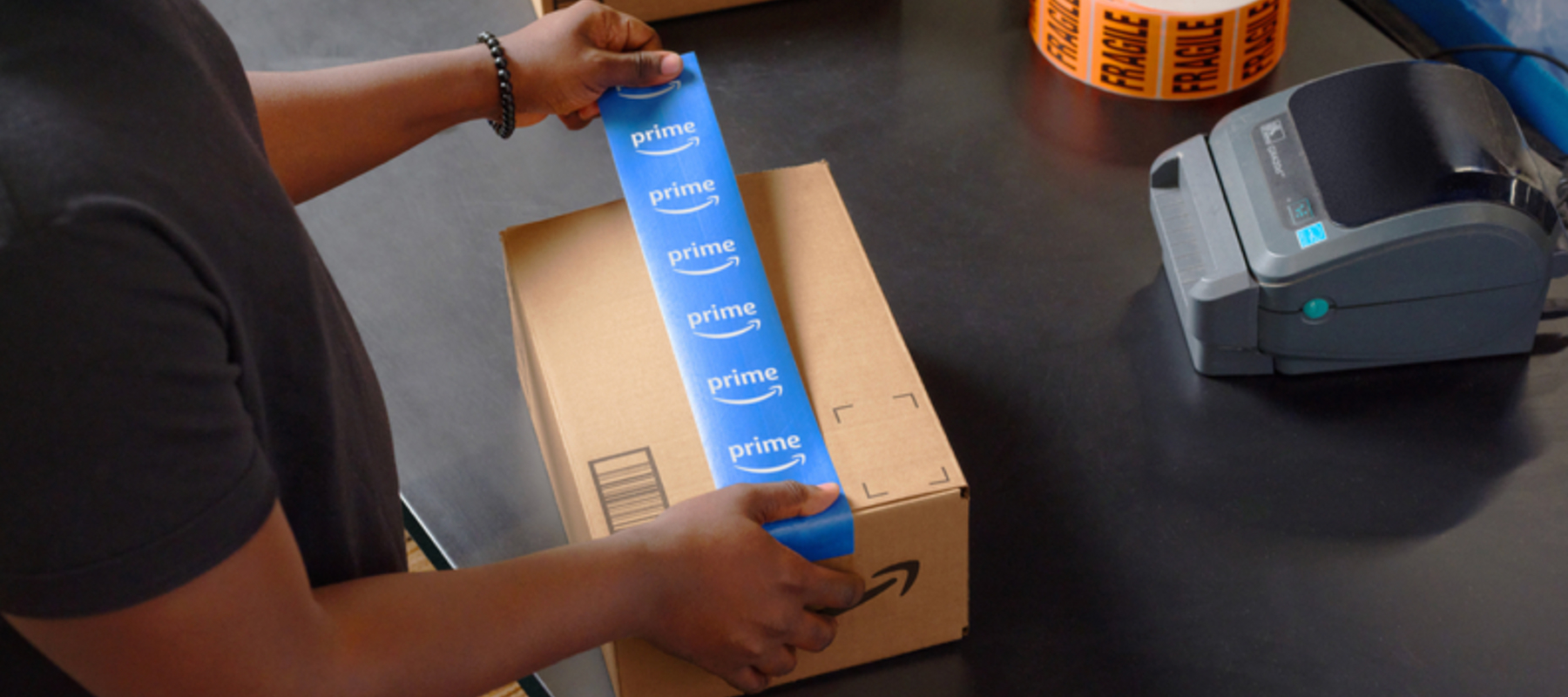 A person places a piece of tape on top of a package. 