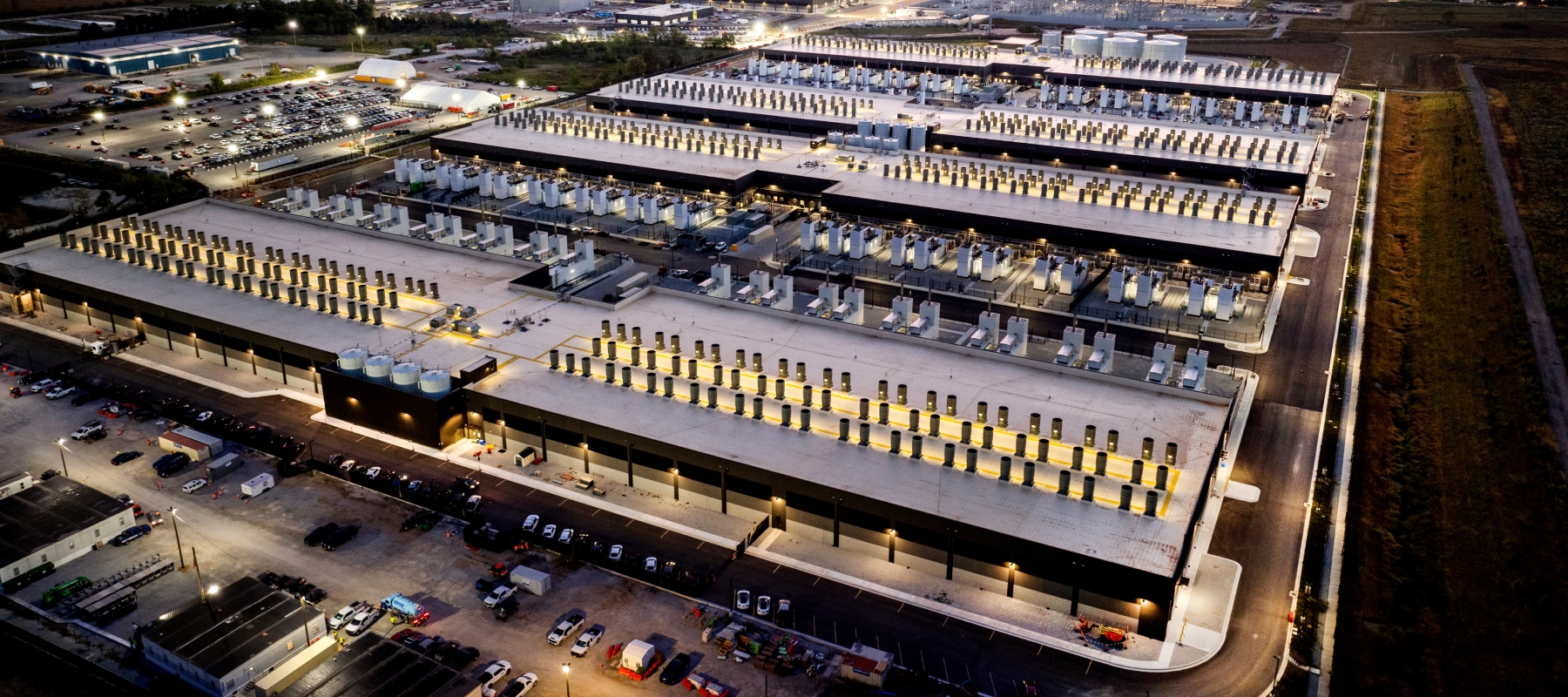 An overhead view shows rows of buildings illuminated at night. 