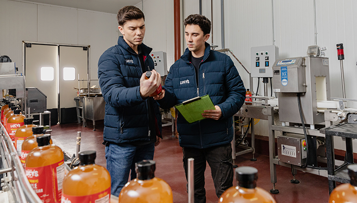 Two people examine bottled products.